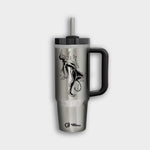 The Polar Monkeys Tumbler is a silver stainless steel tumbler with a black handle and straw, featuring an abstract female figure with plant elements and a small Plastics Pollution Coalition logo near the base.