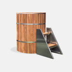The Star Treatment 2.0 Commercial Cold Plunge is a tall, cylindrical wooden ice bath with stainless steel bands and a matching small metal staircase with wooden steps, set against a plain white background—ideal for cold plunge therapy.