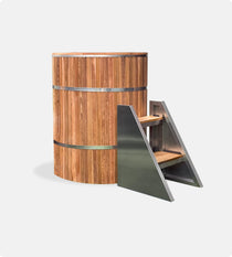 The Star Treatment 2.0 Commercial Cold Plunge is a tall, cylindrical wooden ice bath with stainless steel bands and a matching small metal staircase with wooden steps, set against a plain white background—ideal for cold plunge therapy.