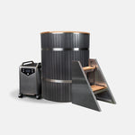 The Star Treatment 2.0 Cold Plunge is a modern cylindrical tub with an integrated seat, dark paneling, metal and wood steps, and a sleek portable chiller on wheels—all thoughtfully designed to fit compact spaces against a plain white background.