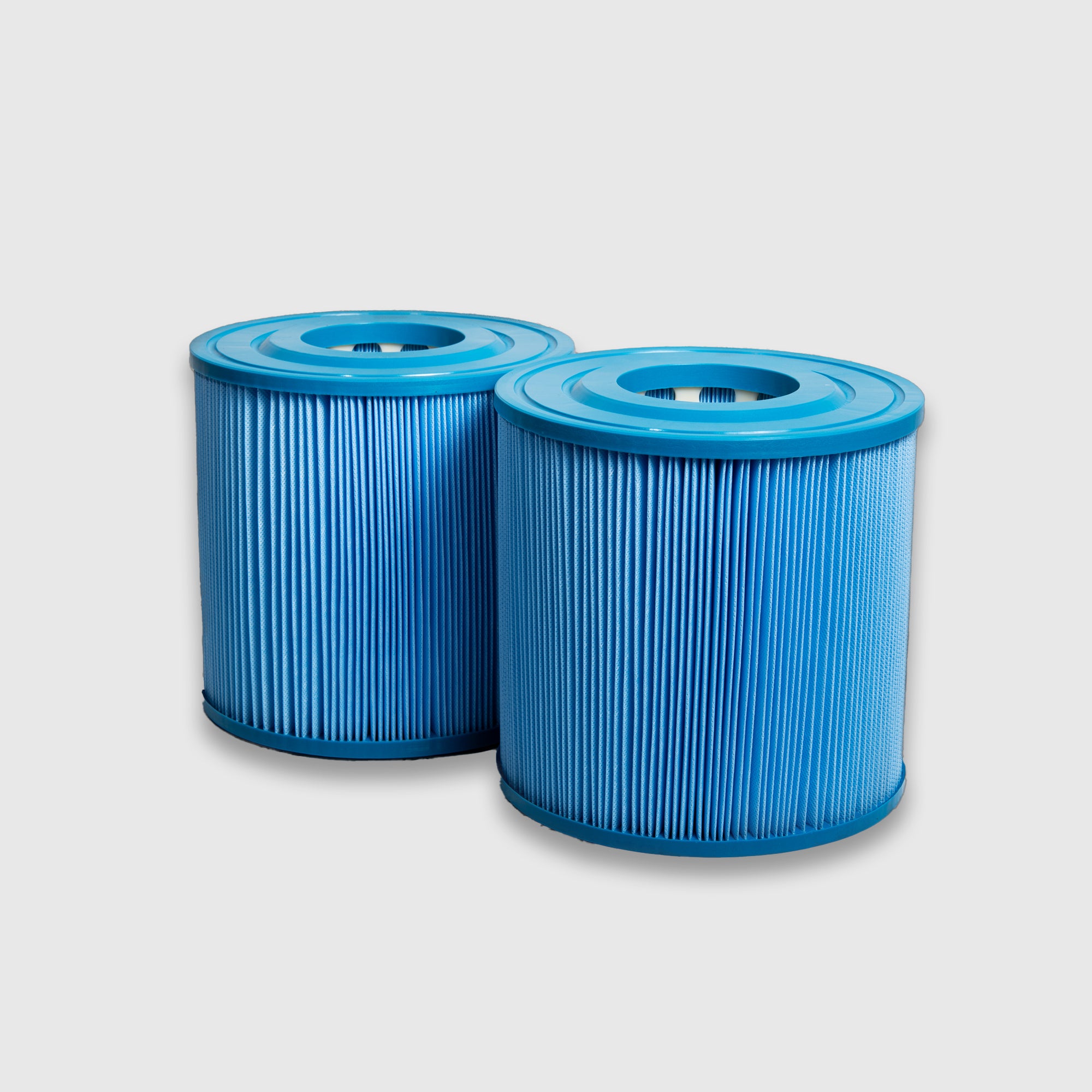 Two blue cylindrical Filter Replacement for Commercial Systems - 2 Pack filters with pleated surfaces stand side by side on a light gray background, designed for excellent compatibility in commercial cold plunge setups.