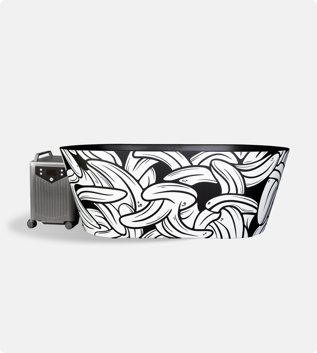 The Brainpod 2.0 Cold Plunge is a black and white insulated acrylic freestanding tub with overlapping banana patterns, paired with a silver and black portable water heater on wheels—ideal for cold plunges against a plain white background.
