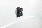 The Brainpod 2.0 Cold Plunge is a black, artist-designed wall-mounted holder with an ergonomic, cylindrical opening to securely hold your showerhead on a white bathroom wall.