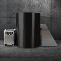 The Cyber Barrel Cold Plunge, a large black cylindrical unit, sits on a concrete floor beside a mobile marine-grade stainless steel system and a slanted metal ramp, set against a textured gray concrete wall.