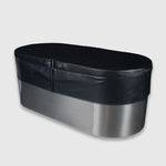 The Insulated Cold Plunge Cover is a large, oval stainless steel tub featuring a black padded marine-grade synthetic leather cover secured with a strap, shown on a plain light gray background.
