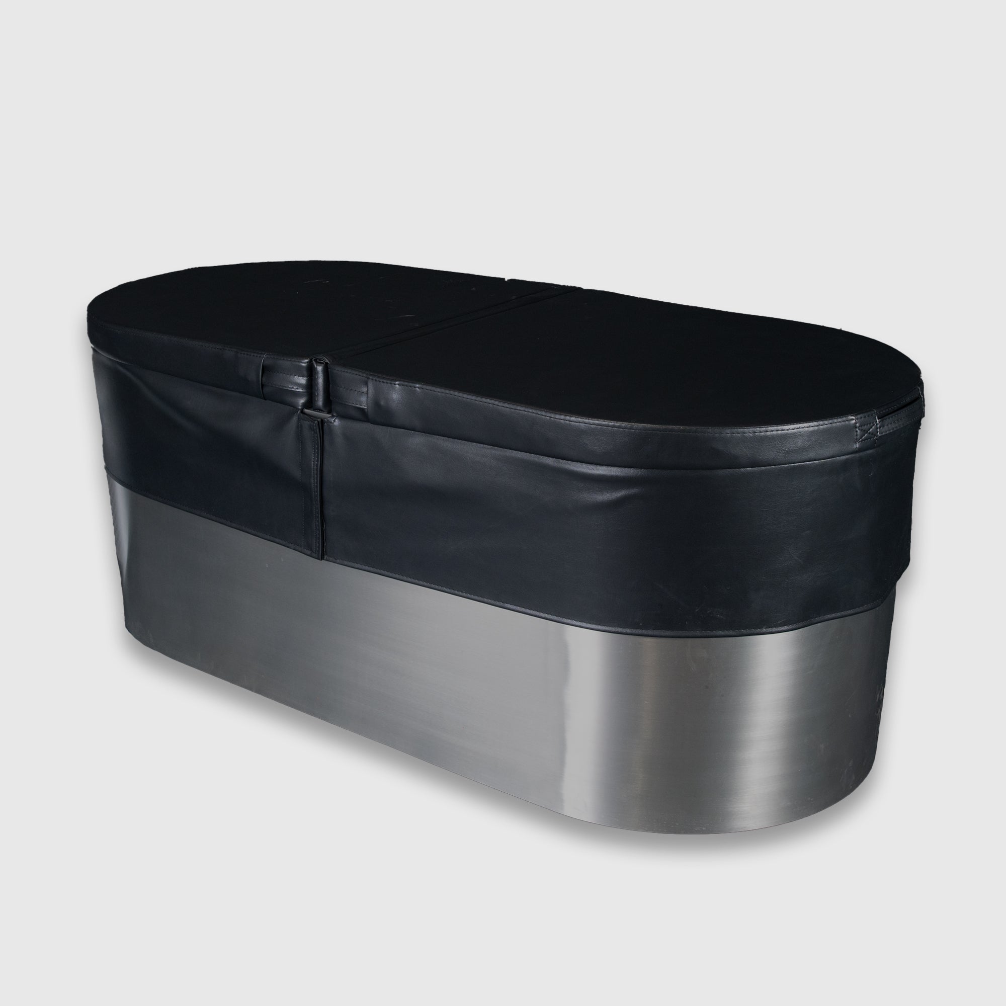 The Insulated Cold Plunge Cover is a large, oval stainless steel tub featuring a black padded marine-grade synthetic leather cover secured with a strap, shown on a plain light gray background.