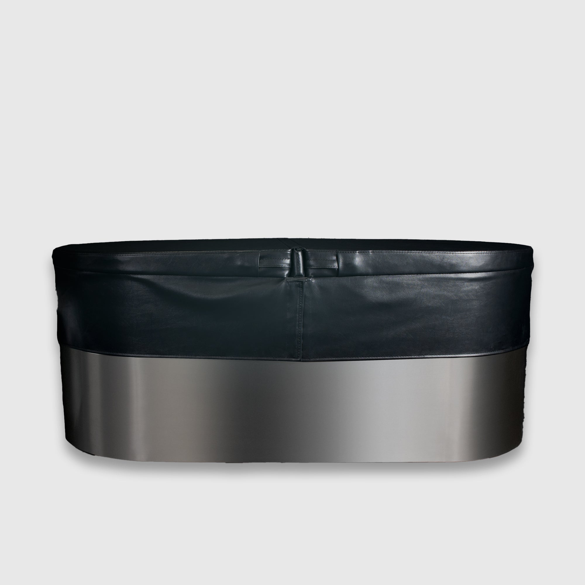 The Insulated Cold Plunge Cover features a modern oval design with a smooth metallic lower section, black upper rim, and marine-grade synthetic leather details, shown against a plain light gray background.