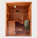 The Baia Glass Sauna features a modern design with a glass door, a bench with a curved backrest, and includes both a bucket and ladle. On the right side, sauna stones are elegantly arranged in a sleek metal holder. This clean and well-lit sauna provides comfort and contemporary style.