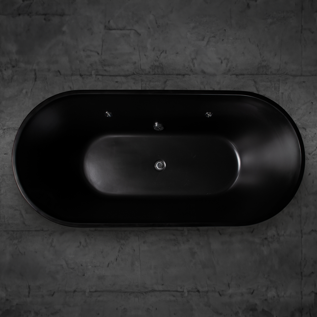 A top-down view of the Brainpod 2.0 Commercial Cold Plunge—a sleek black oval tub with ergonomic design—set against a dark gray stone wall. Its minimalist style and smooth finish give it a modern, luxurious look.