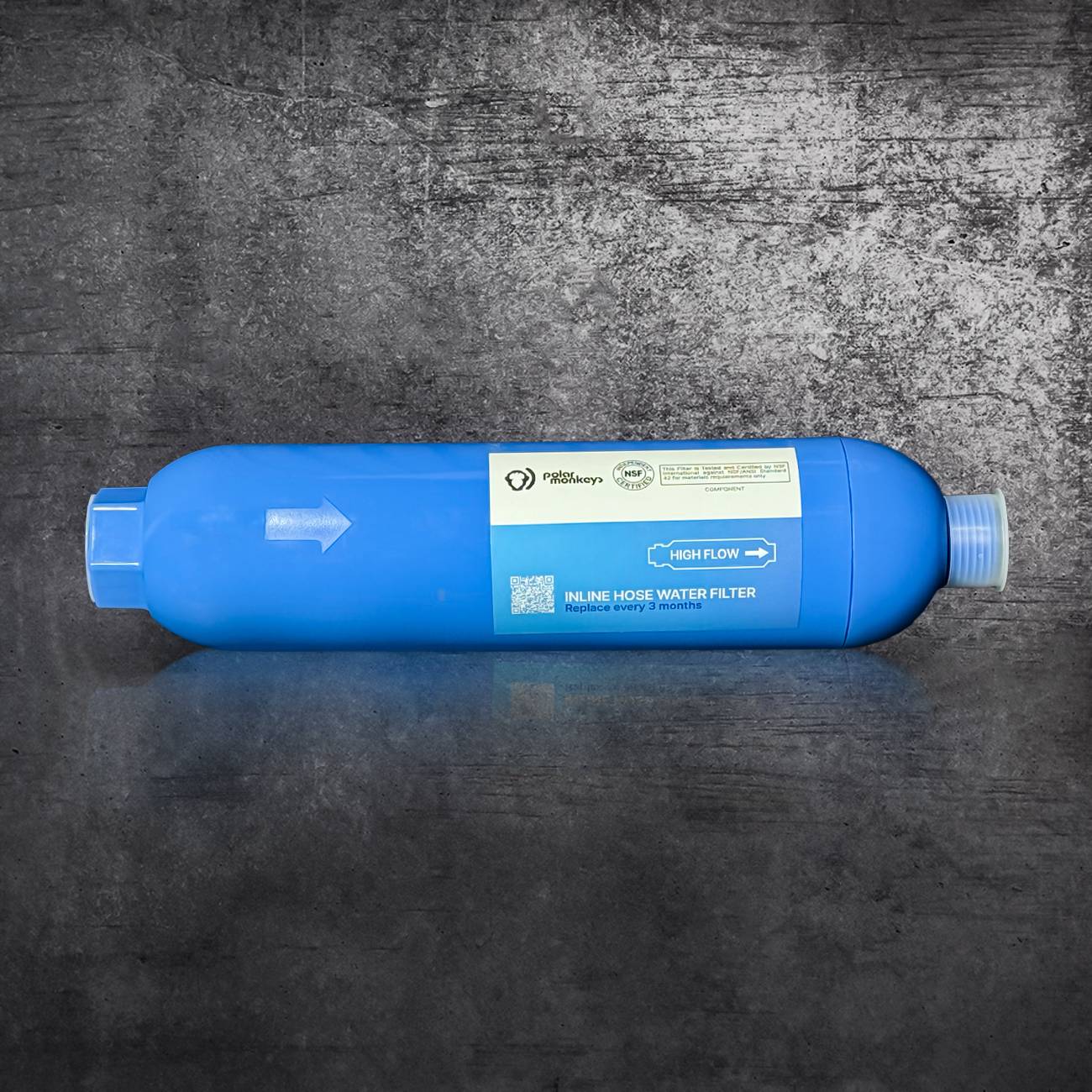 The Hose Water Filter is a blue, cylindrical filter with multi-stage filtration and labeled instructions showing water flow direction. It lies horizontally on a textured gray surface, making it perfect for cold plunge setups.