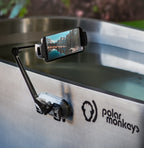 A smartphone is secured in the PolarMonkeys Smart Device Holder, a waterproof and flexible mount attached to a stainless steel ice bath, ideal for capturing scenic cold plunge moments.