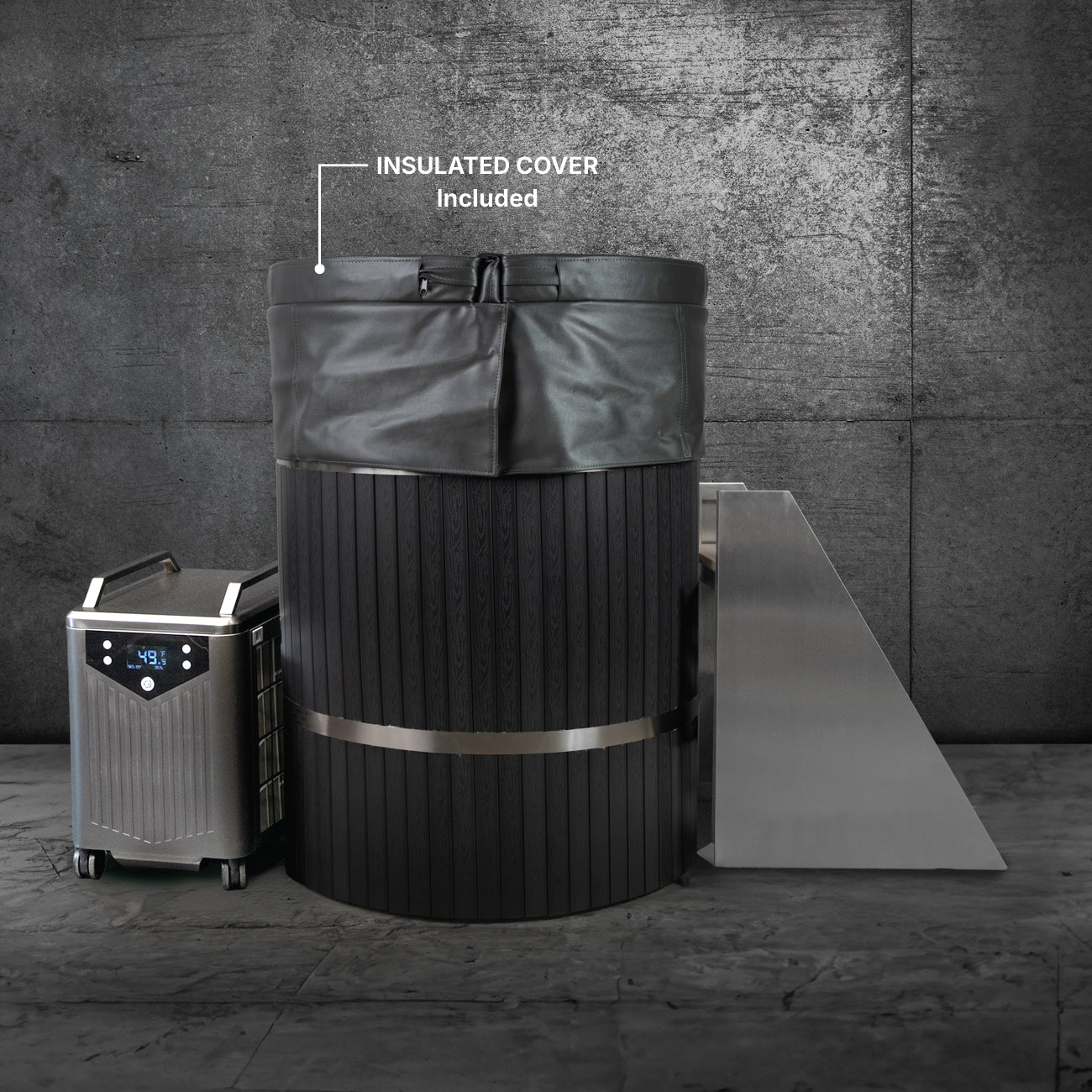 The Star Treatment 2.0, a premium black cold plunge tub with an insulated cover and chiller display, fits compact spaces. A metal ramp leads to the tub, all set against a stylish dark industrial backdrop.