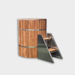The Star Treatment 2.0 Commercial Cold Plunge is a tall, cylindrical wooden ice bath with stainless steel bands and a matching small metal staircase with wooden steps, set against a plain white background—ideal for cold plunge therapy.