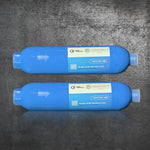Two Hose Water Filter - 2 Pack units with labels and arrows are placed side by side on a textured gray surface, illustrating their multi-stage filtration design.