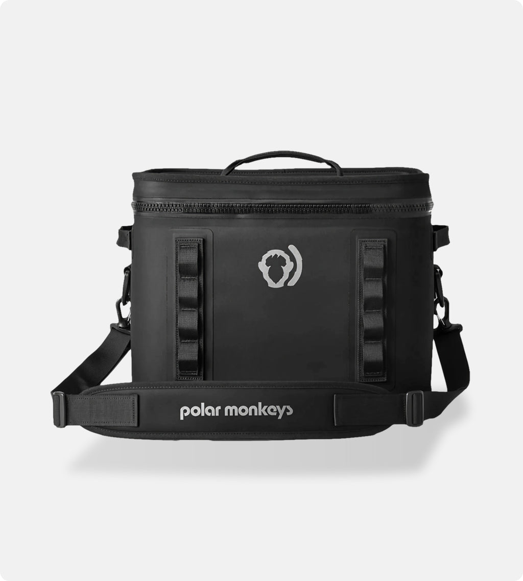 The Cave Cooler, a black soft cooler bag featuring leak-proof insulation, a handle, shoulder strap, and the Polar Monkeys logo on the front, is photographed against a plain light background.